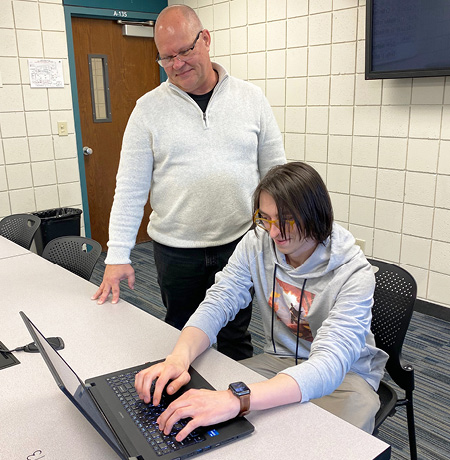 Technical Support Services - Technician assisting student using a laptop